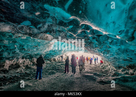Les touristes dans la grotte de cristal, Glacier Breidamerkurjokull, Islande. La glace bleue émeraude et le frêne fait partie d'Breidamerkurjokull. Banque D'Images