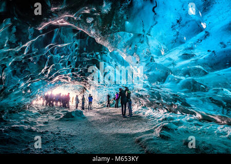Les touristes dans la grotte de cristal, Glacier Breidamerkurjokull, Islande. La glace bleue émeraude et le frêne fait partie d'Breidamerkurjokull. Banque D'Images