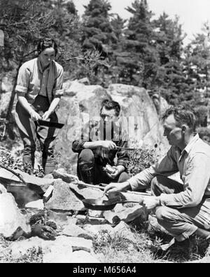 Années 30, DEUX HOMMES UNE FEMME TENANT LA POÊLE ASSIS ACCROUPI AUTOUR D'UN REPAS DE CUISINE DE CAMP LAC DES BOIS ONTARIO CANADA - c8000 HAR001 HARS, préparer l'ESPACE RURAL COPIE AMITIÉ Mesdames pleine longueur de camp rugueux de l'ONTARIO UNITÉ NOSTALGIE 35-40 ans 40-45 ans AVENTURE DÉTENTE LOISIRS FAIM CONNAISSANCES SOUPER PETIT GROUPE DE PERSONNES POÊLE LAC DES BOIS MI-hommes mi-homme adulte ADULTES MID-ADULT WOMAN B&W NOIR ET BLANC PORTRAIT DE L'ORIGINE ETHNIQUE DES PERSONNES À L'ANCIENNE ACCROUPIE Banque D'Images