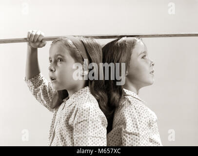 1960 TWINS IN VERGE EN VERTU DE LA MESURE DE HAUTEUR - j12588 HAR001 HARS FRÈRES SOEURS NOSTALGIE UNITÉ 3-4 ans 5-6 ans CORRESPONDANT À MÊME LA CROISSANCE D'UN SEUL OBJET DE CONNEXION D'ENFANT DE POLKA DOT À PRÉSENTATION LES CHEVEUX LONGS COMME LES juvéniles de plus B&W dos à dos noir et blanc de l'origine ethnique caucasienne BLOUSES les serre-têtes old fashioned SAMENESS STUDIO PLUS COURTE RÉFÉRENCE PLUS COURTE Banque D'Images