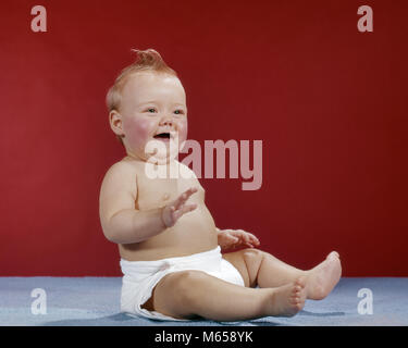 1960 BÉBÉ PORTANT COUCHE EN TISSU ASSISE RIRE HEUREUX - kb5037 HAR001 HARS NOSTALGIE 0-1 ANS BONHEUR JOYEUX EXCITATION HAIRSTYLE HOOGSTRATEN JOYEUX SOURIRES K CROISSANCE DE CHEVEUX ROUGE 6-12 MOIS LES MINEURS DE L'axe de l'origine ethnique caucasienne de fille de bébé à l'ANCIENNE MOHAWK Banque D'Images