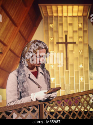 1960 FEMME EN PRIÈRE À L'ÉGLISE HOLDING BIBLE - kc3098 HAR001 HARS, adulte, à l'intérieur de la spiritualité chrétienne bienveillante nostalgie de 20 à 25 ans 25 à 30 ANS LE CHRISTIANISME PRIER COMMUNIQUER CONCEPTUEL CONSACRÉ ÉGLISES MID-ADULT MID-ADULT WOMAN l'écriture de l'origine ethnique caucasienne CATHOLIQUE CRUCIFIX FOULARD OLD FASHIONED PERSONNES Banque D'Images