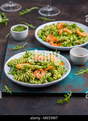 Deux portions de pâtes au pesto de roquette et crevettes frites Banque D'Images