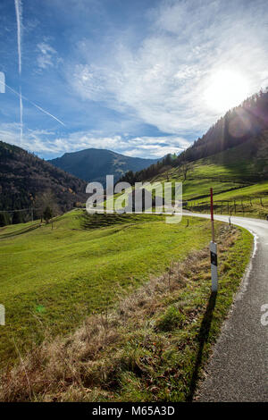 Route de campagne dans les Alpes d'Allgäu, le Hochgrad la montagne au milieu. Photo prise contre le soleil. Près de, Steibis, Allgäu, Bavière, Allemagne, Europe. Banque D'Images