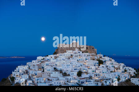 Chora d'Astipalea en bleu l'heure et la pleine lune derrière la forteresse Banque D'Images