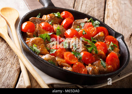 Les aliments biologiques : boeuf en sauce épicée aux tomates et les verts gros plan sur une poêle sur une table horizontale. Banque D'Images