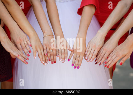 Mariée et demoiselles d'afficher des bouquets de fleurs. La mariée et ses amies se tiennent côte à côte et montrer les bouquets dans les mains. Mariée avec des fleurs Banque D'Images