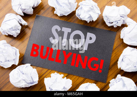 La main légende montrant arrêter l'intimidation. Concept d'affaires pour la prévention Problème Bully écrit sur sticky note le papier de fond en bois avec Banque D'Images