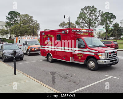 D'ambulanciers paramédicaux d'incendie et de sauvetage avec un Haynes Ambulance garée derrière répondant à une urgence médicale à Montgomery, en Alabama, USA. Banque D'Images