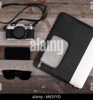 Smartphone, appareil photo et ordinateur portable sur fond de bois Banque D'Images