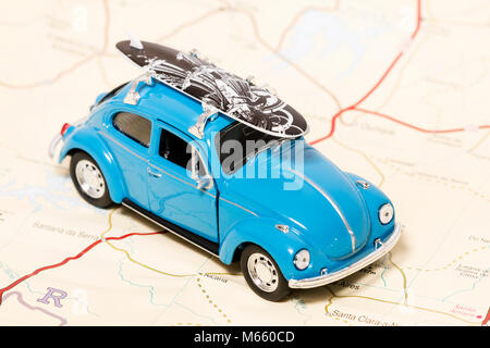 Un concept de voyage vintage beetle avec planche de surf sur une carte. Banque D'Images