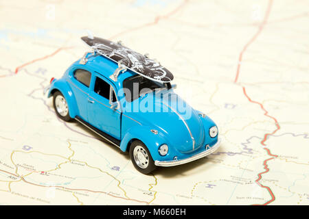 Un concept de voyage vintage beetle avec planche de surf sur une carte. Banque D'Images