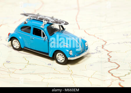 Un concept de voyage vintage beetle avec planche de surf sur une carte. Banque D'Images