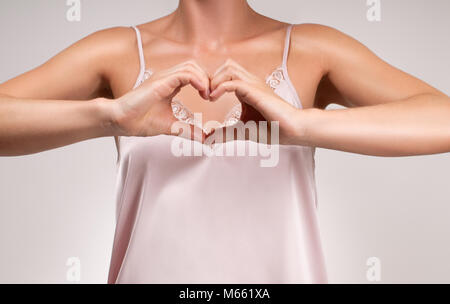 Femme montrant sur ses mains en forme de coeur Banque D'Images
