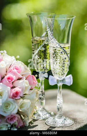 Les anneaux de mariage avec des roses et des verres de champagne Banque D'Images