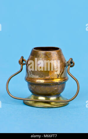 Marmite en cuivre laiton décoratif avec poignée sur fond bleu azur Banque D'Images
