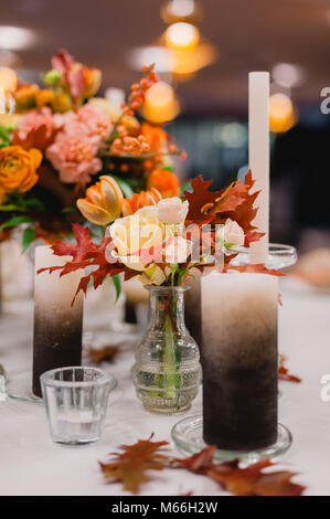 Les bougies blanches sur les chandeliers debout sur les tables de restaurant ronde préparé pour un mariage Banque D'Images