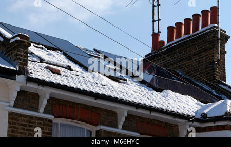 La neige est autorisé à partir de 10 panneaux solaires photovoltaïques sur le toit d'une maison d'époque dans Lewisham Banque D'Images