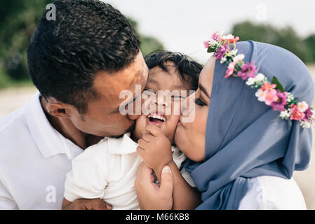 Mère et père de famille de l'Asie embrassant leurs fils concept de famille. Banque D'Images