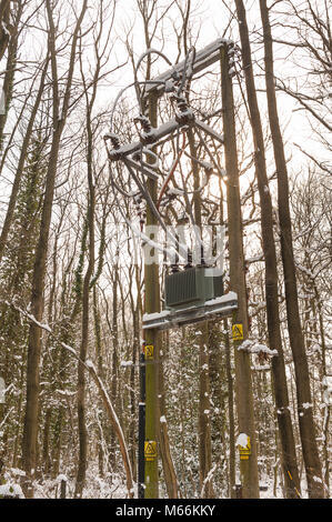 Phase trois sur poteau transformateur secteur haute tension avec de la neige gelée et de glaçons causant des problèmes de distribution d'électricité sur le réseau national des Banque D'Images