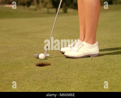 1960 Portrait de femme jambes vêtus de blanc ET DES CHAUSSURES DE GOLF PUTTER CLUB À PROPOS DE BALLE DANS LA COURSE DE LA COUPE DU TROU SUR LE GREEN - kg3210 HAR001 HARS NOSTALGIE FEMME DE 20 à 25 ans 25-30 ans 30-35 ans COURS OBJECTIFS ANGLE FAIBLE LOISIRS LOISIRS SPORTIFS CONCEPTUELLE CLOSE-UP GOLF LOISIRS TAPPING MID-ADULT MID-ADULT WOMAN PUTT PUTTER Précision de l'origine ethnique caucasienne GENOU JAMBES SEULEMENT DÉMODÉ PAR PERSONNES ET UN VERT DE CARESSER LE LIVRE VERT Banque D'Images