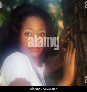 1970 African American Woman Portrait en extérieur par TREE LOOKING AT CAMERA - kg7565 HAR001 HARS, LOOKING AT CAMERA OLD FASHIONED PERSONNES Banque D'Images