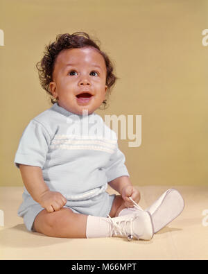 1970 SMILING FRISÉS AFRICAN AMERICAN BABY BOY SITTING HEUREUX À LA RECHERCHE VERS LE HAUT - kn497 HAR001 HARS CHEERFUL africains-américains africains-américains NOIR ETHNIQUE NOIR ORIGINE AMÉRICAINS AFRICAINS AFRICAN AMERICAN BABY BOY JOYEUX SOURIRES 1-6 mois 6-12 mois les mâles juvéniles à l'ANCIENNE CHEMISE BLEU VERS LE HAUT Banque D'Images