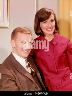 1960 PORTRAIT SMILING YOUNG COUPLE HOMME EN COSTUME WOMAN WEARING RED DRESS - kp1117 HAR001 FEMELLES HARS PORTRAITS MARIÉS MARI CONJOINT SANTÉ GROWNUP ACCUEIL COPIE ESPACE VIE demi-longueur d'AMITIÉ MESDAMES ADULTE, DES COUPLES à l'intérieur UNITÉ NOSTALGIE DE LA CONFIANCE DANS LES YEUX de 20 à 25 ans 25 à 30 ans, costume et cravate JEUNE FEMME JOYEUSE OCCASION BONHEUR LOISIRS 18-19 ANS SOURIRES JOYEUX CONNEXION PERSONNES mâles adultes YOUNG ADULT MAN WOMAN Origine ethnique Caucasienne LOOKING AT CAMERA OLD FASHIONED PERSONNES Banque D'Images