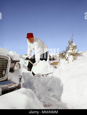 Années 1950 Années 1960 Homme portant un bonnet rouge CREUSER HORS DE SA VOITURE de pelleter de la neige dans la voie privée - KW1866 HAR001 HARS 35-40 ANS PELLETER DE FLEXION DU TRAVAIL FORCE Les mâles adultes de compensation mi-homme mi-adulte l'origine ethnique caucasienne ÉREINTANT LABORIEUX NO FUN OLD FASHIONED PERSONNES Banque D'Images