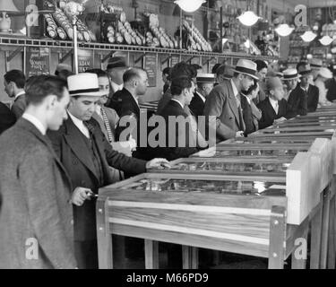 Groupe 1930 hommes portant des chapeaux en jouant les billards électriques dans la salle de Broadway, Times Square NEW YORK CITY USA - q74791 CPC001 HARS MIDTOWN EN ARCADE GOTHAM MACHINES LOISIRS EXCITATION NYC NEW YORK VILLES GROUPE DE PERSONNES NEW YORK CITY TIMES SQUARE, BROADWAY MI-hommes mi-ADULTES ADULT MAN B&W BIG APPLE NOIR ET BLANC PORTRAIT DE L'ORIGINE ETHNIQUE DES PERSONNES À L'ANCIENNE JEUX PINBALL Banque D'Images