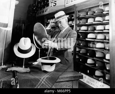 1940 MAN ESSAYANT DES CHAPEAUX À LA RECHERCHE DE MIROIR DANS HAT STORE - s7811 HAR001 HARS BOUTIQUES À L'INTÉRIEUR DES CADRES DE CONFIANCE HOMME SENIOR ADULTE NOSTALGIE middle-aged homme d'âge moyen 55-60 ans 60-65 ans shopper costume et cravate anciens styles antiques anciens magasins masculin essayant CHOIX FASHIONS PATRONS D'ESSAYER LES VÊTEMENTS HOMMES MIROIRS GESTIONNAIRES B&W NOIR ET BLANC PORTRAIT DE L'ORIGINE ETHNIQUE DES PERSONNES À L'ANCIENNE Banque D'Images