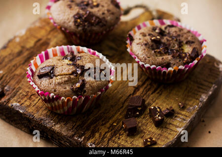 Des muffins au chocolat sur une vieille planche de bois Banque D'Images