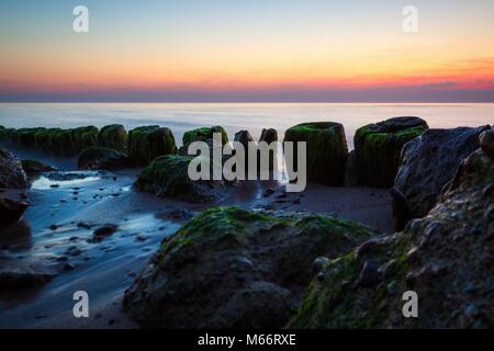Gros plan d'un brise-lames pendant le lever du soleil. Banque D'Images