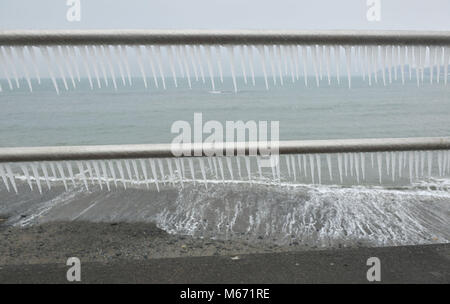 Formulaire de glaçons sur le front de mer de Penzance en Cornouailles à garde-corps, qu'un autre jour de températures extrêmes, à des vents glacés et des conditions de blizzard est prévu, comme Emma tempête balaie de l'Atlantique sur la queue de la bête de l'est fait froid explosion. Banque D'Images