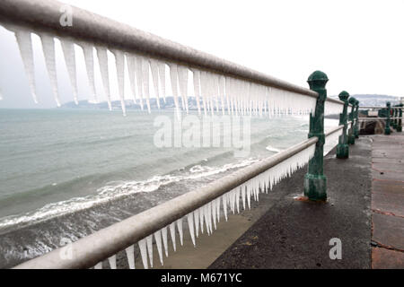 Formulaire de glaçons sur le front de mer de Penzance en Cornouailles à garde-corps, qu'un autre jour de températures extrêmes, à des vents glacés et des conditions de blizzard est prévu, comme Emma tempête balaie de l'Atlantique sur la queue de la bête de l'est fait froid explosion. Banque D'Images