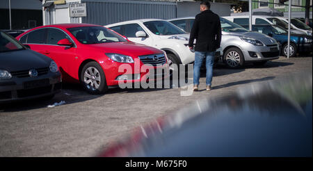 Stuttgart, Allemagne. 28 Février, 2018. Un vendeur de voiture à la recherche de modèles diesel de producteurs différents à un concessionnaire de voitures d'occasion à Stuttgart, Allemagne, 28 février 2018. Après la décision prise par le tribunal administratif fédéral sur la question des interdictions de circuler, plusieurs États et communautés espèrent être en mesure d'entraver davantage l'interdiction du diesel. Crédit : Sébastien Gollnow/dpa/Alamy Live News Banque D'Images