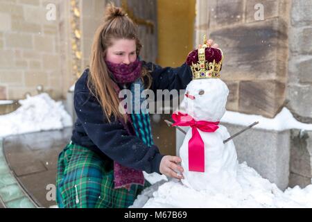 Edinburgh, Royaume-Uni. 1er mars 2018. Météo France : Le personnel du palais de Holyrood House à Édimbourg ont fait un royal bienvenue aux visiteurs aujourd'hui par la construction d'une reine des neiges riche d'une couronne sur sa tête. Sur la photo : Elaine Bridge, l'un des membres du personnel l'ajout de la couronne de la reine des neiges à l'extérieur du lieu Centre d'accueil. Credit : Riche de Dyson/Alamy Live News Banque D'Images