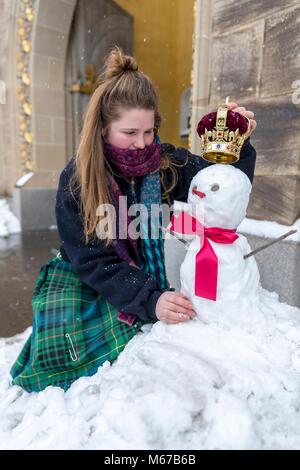 Edinburgh, Royaume-Uni. 1er mars 2018. Météo France : Le personnel du palais de Holyrood House à Édimbourg ont fait un royal bienvenue aux visiteurs aujourd'hui par la construction d'une reine des neiges riche d'une couronne sur sa tête. Sur la photo : Elaine Bridge, l'un des membres du personnel l'ajout de la couronne de la reine des neiges à l'extérieur du lieu Centre d'accueil. Credit : Riche de Dyson/Alamy Live News Banque D'Images