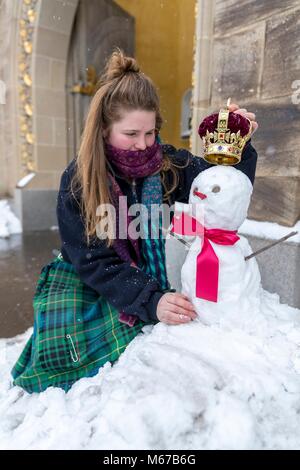 Edinburgh, Royaume-Uni. 1er mars 2018. Météo France : Le personnel du palais de Holyrood House à Édimbourg ont fait un royal bienvenue aux visiteurs aujourd'hui par la construction d'une reine des neiges riche d'une couronne sur sa tête. Sur la photo : Elaine Bridge, l'un des membres du personnel l'ajout de la couronne de la reine des neiges à l'extérieur du lieu Centre d'accueil. Credit : Riche de Dyson/Alamy Live News Banque D'Images