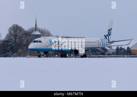 La neige a couvert l'aéroport. Flybe Embraer ERJ-195 le roulage à l'aéroport de Londres Southend dans la neige au cours de la bête de l'est phénomène météo Banque D'Images