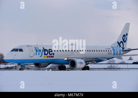 La neige a couvert l'aéroport. Flybe Embraer ERJ-195 le roulage à l'aéroport de Londres Southend dans la neige au cours de la bête de l'est phénomène météo Banque D'Images