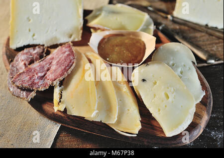 Planche en bois de délicieux fromages et charcuterie salami avec confiture de figues Banque D'Images