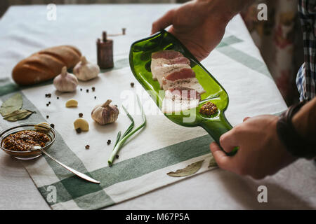 Seulement les mains. L'homme termine son assiette et presque prêt à servir à la table. Décoration de la table. Plats de service. Manger dans de beaux plats. Russi Banque D'Images