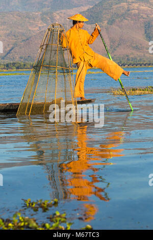 Intha leg rameur pêcheurs à Shan State, Inle Lake, Myanmar (Birmanie), Asie en février - pêcheur utilisant le pied sur le goudron pour pagayer tout en tenant le filet Banque D'Images