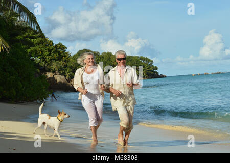 Vieux couple running on beach Banque D'Images