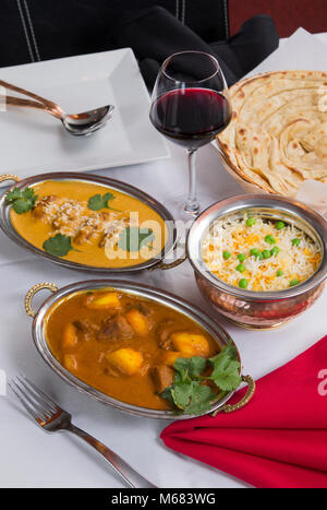 Aliments curry indien étendu sur une table de dîner de fantaisie avec du riz, de l'laccha, agneau Paratha Placez aam wala, safran malai kofta, vin rouge. Banque D'Images
