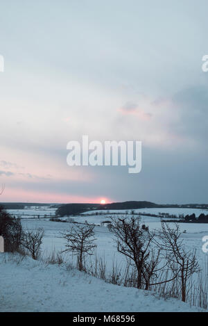 Coucher de soleil sur les champs et les collines couvertes de neige dans la région de South Lincolnshire Banque D'Images