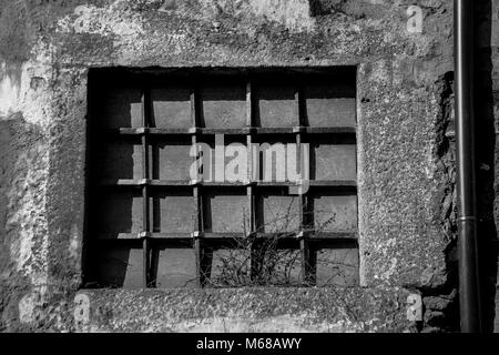 Image en noir et blanc de la porte de la grille de fer plus de fenêtre à bord Banque D'Images