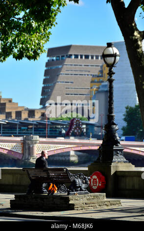 Londres, Angleterre, Royaume-Uni. Tate Modern's new Pyramid Tower (2016) vu de l'autre côté de la Tamise. Homme assis sur un banc sur le quai Banque D'Images