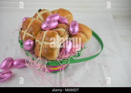 La nourriture dans un panier de Pâques avec les brioches et les oeufs de Pâques au chocolat Banque D'Images